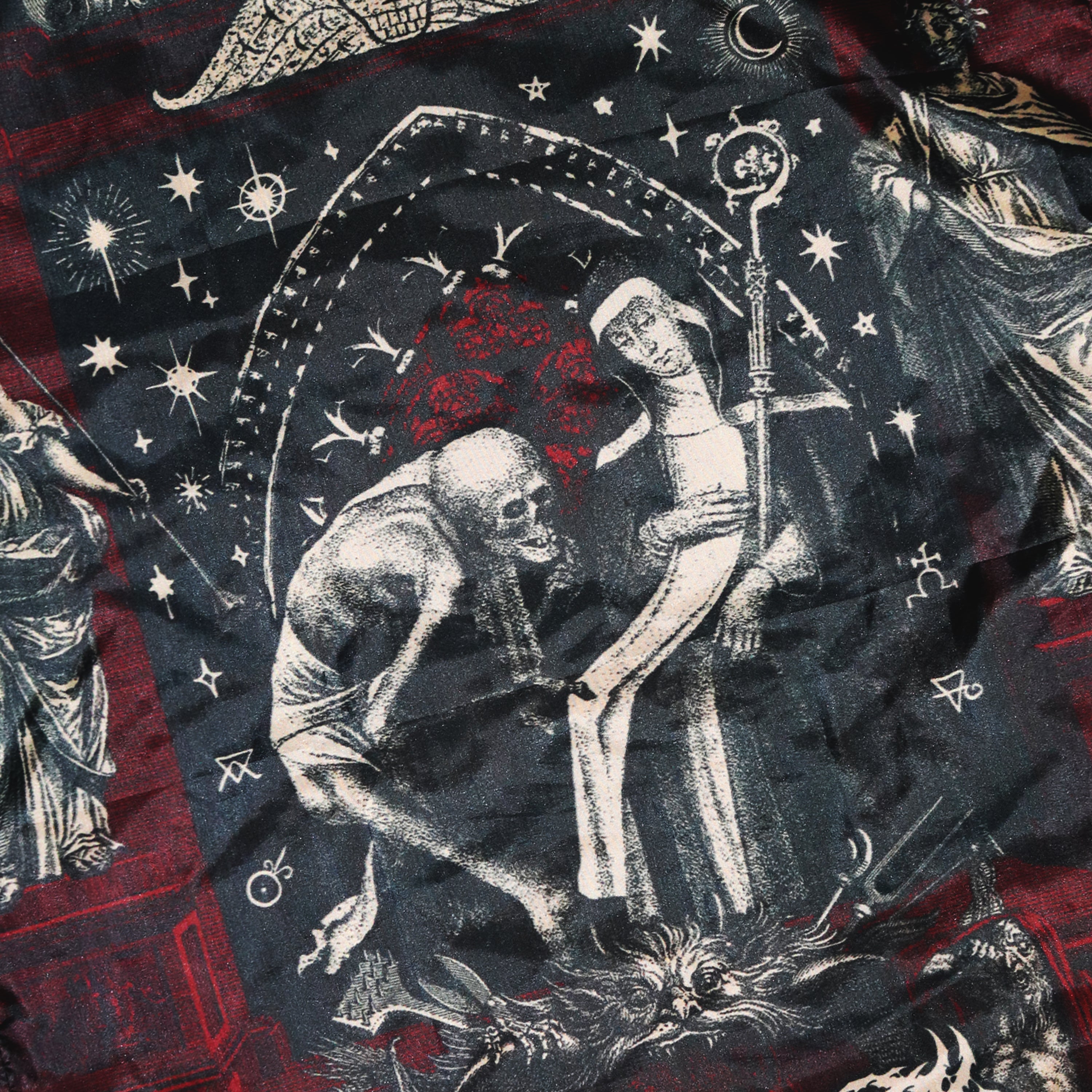 Death Gate Damnation Flag 
Close-up of a fabric with gothic-style design featuring skeletons and celestial elements.